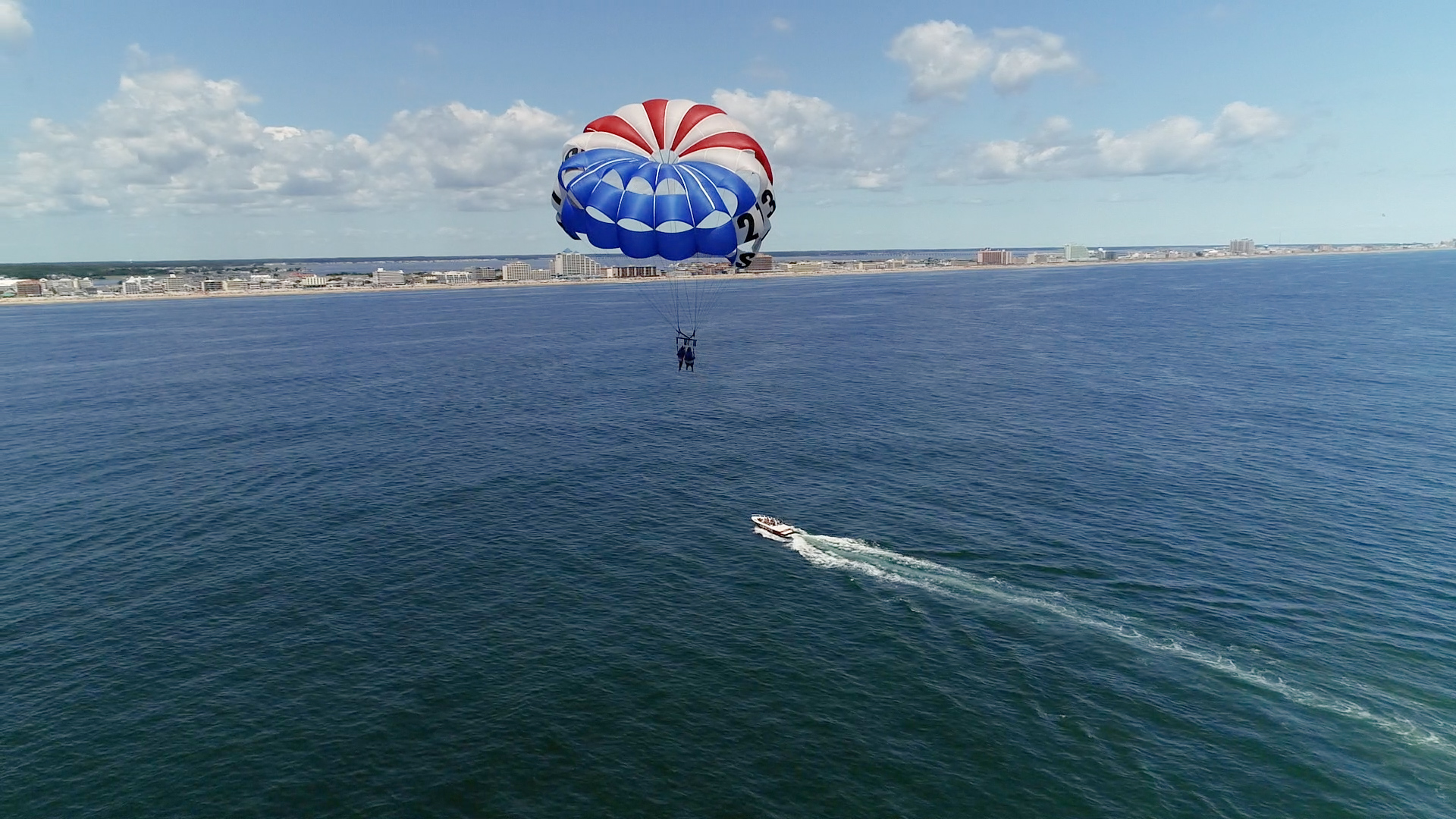 Aerial view of parasailer over ocean coastline