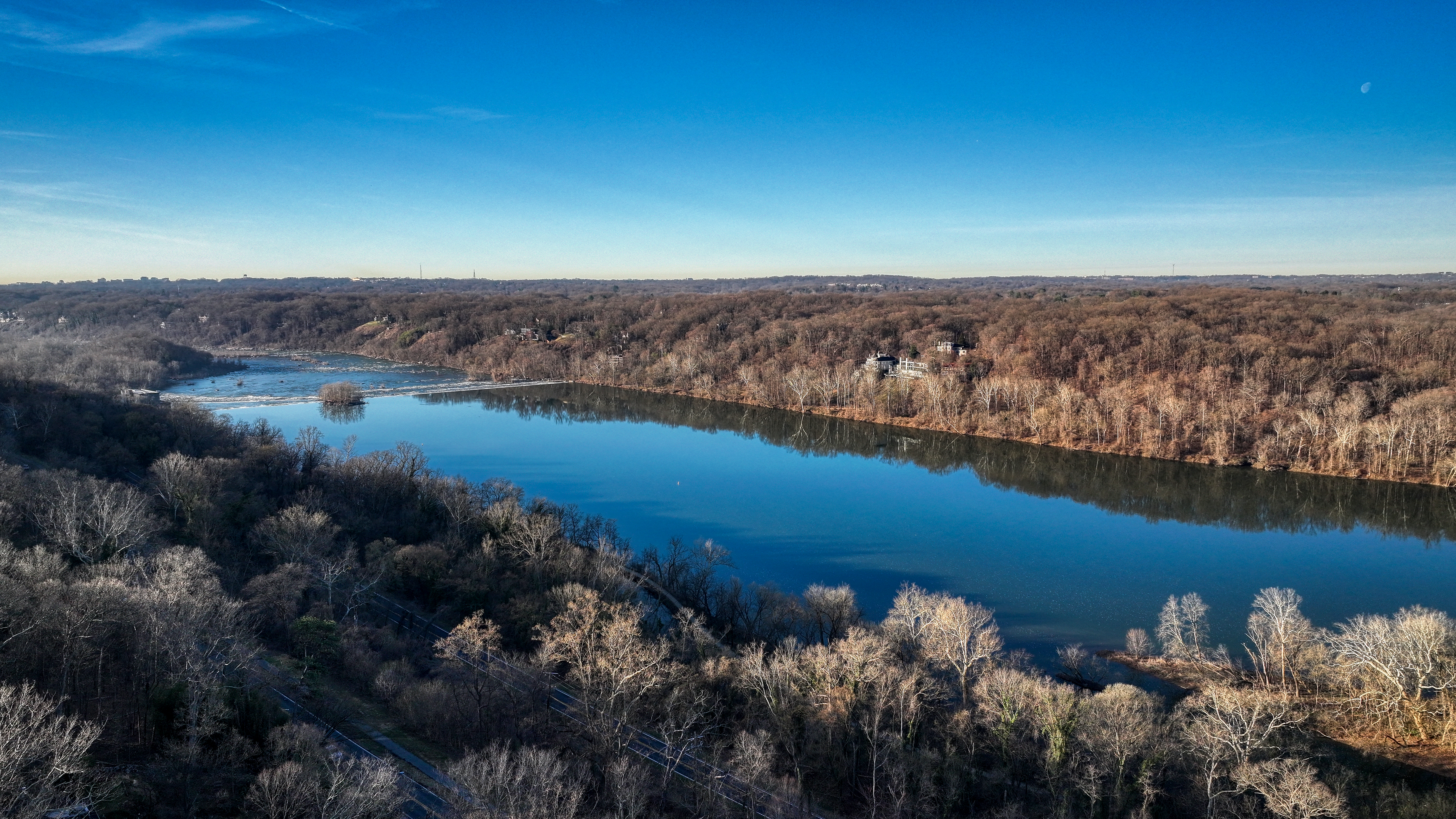 Aerial view of river with wooded shoreline and estate